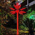 Red LED palm tree light outdoor display on black background, high-visibility decorative lighting