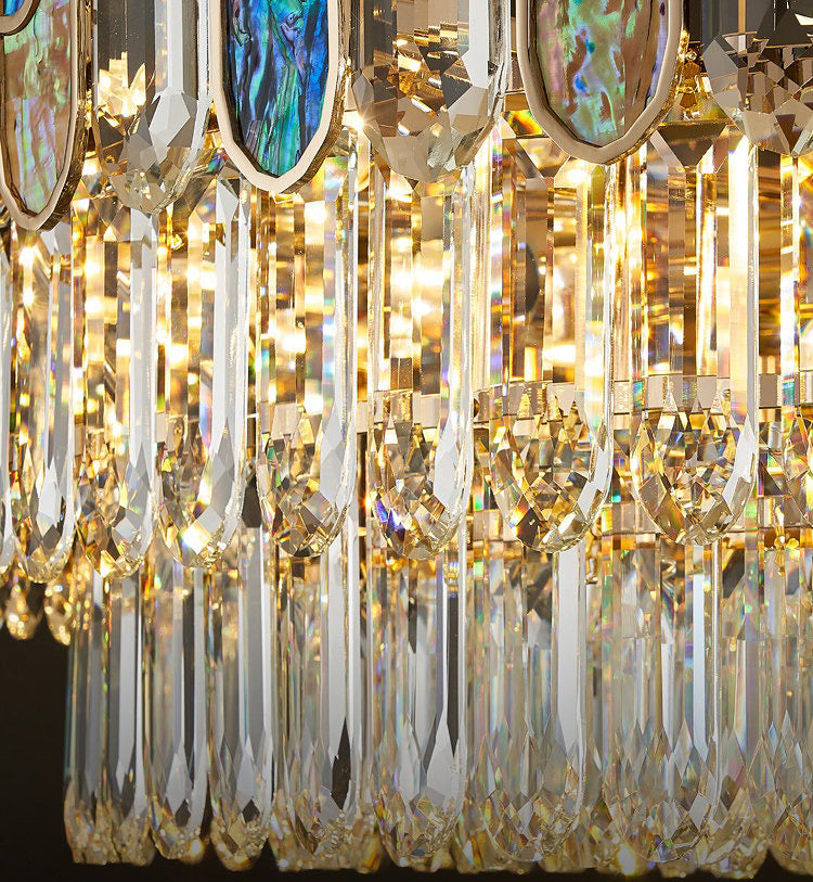 Detailed view of blue abalone glass and crystal pendants on gold chandelier