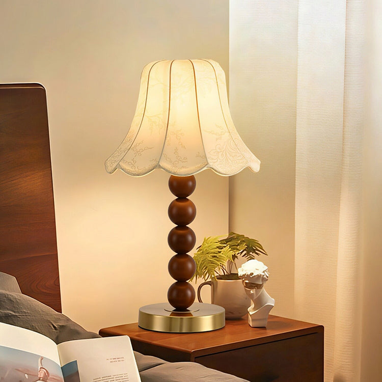 French floral fabric table lamp beside bed in warm bedroom