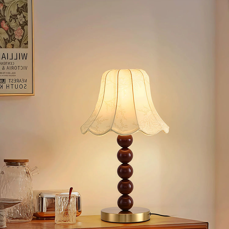 French floral fabric table lamp on wooden cabinet with glass decor