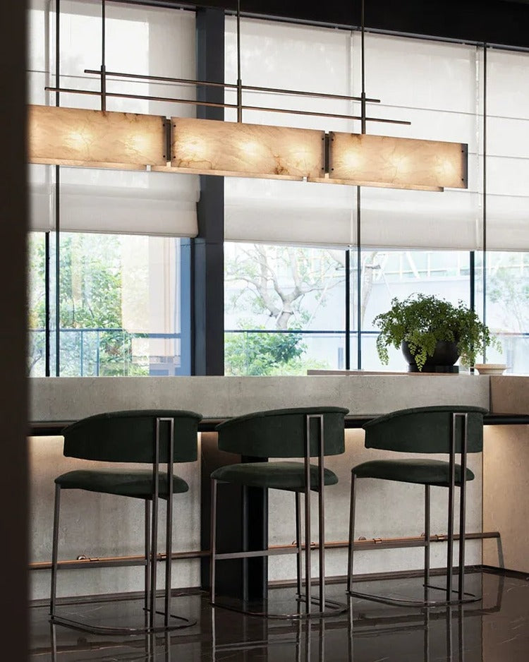 Rectangular alabaster brass chandelier above bar counter seating