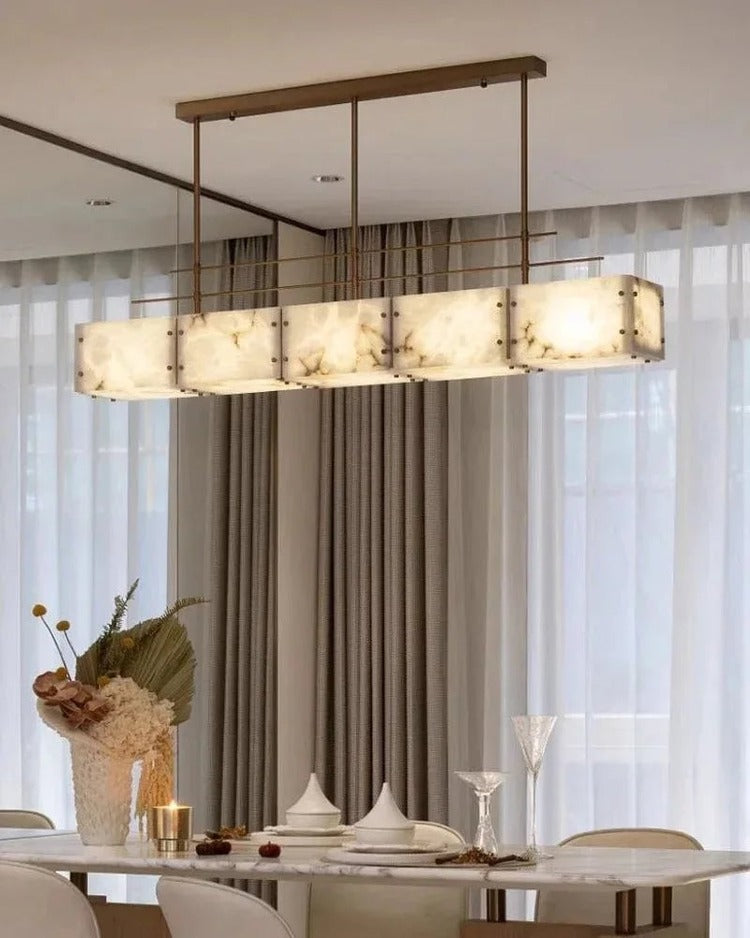 Rectangular alabaster brass chandelier over dining table beside tall windows