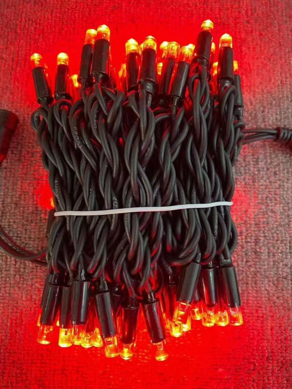 Red rubber wire LED string lights with black wire close up